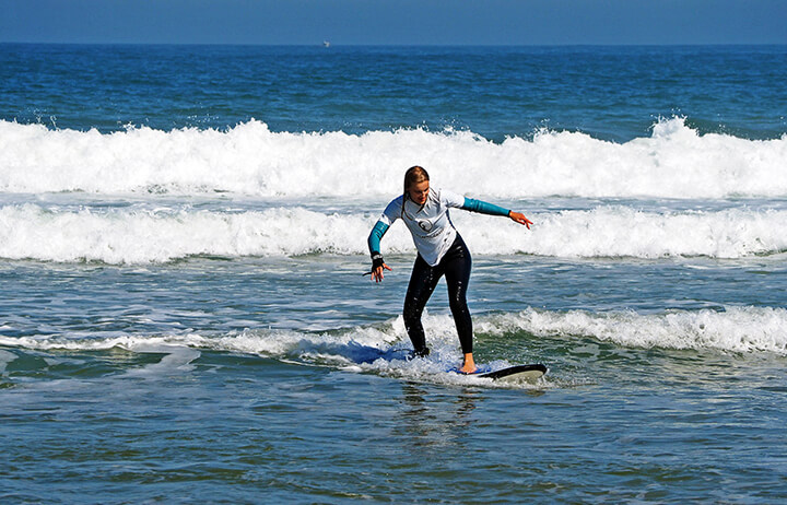 surfer girl rides wave on 5 days surf course in Praia Azul - Santa Cruz, ocean, sunshine, beach