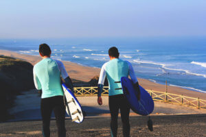 2 surfers walk down to the beach from Atlantic Coast Surf School, in Praia Azul - Santa Cruz. Empty beach