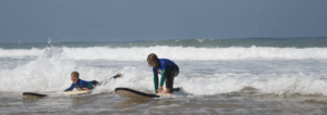 children surfing on the beach. surf has a lot of benefits for kids